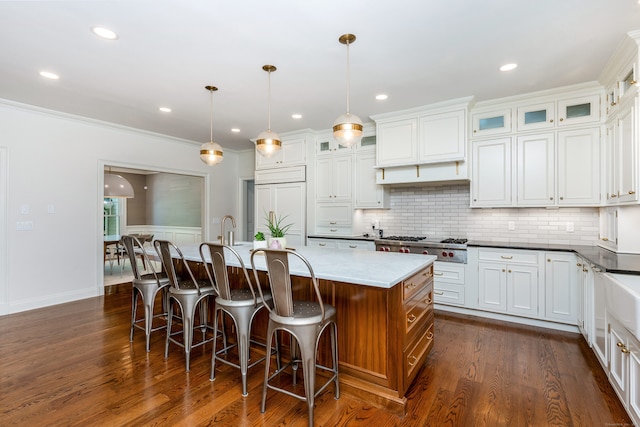 21 Park Pl, Darien, CT 06820 - kitchen with dark wood finished floors, stainless steel gas stovetop, a center island with sink, tasteful backsplash, and recessed lighting
