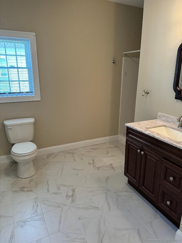 60 Pinehurst Dr Unit 60, East Haven, CT 06513 - bathroom featuring vanity, toilet, baseboards, and marble look tile flooring