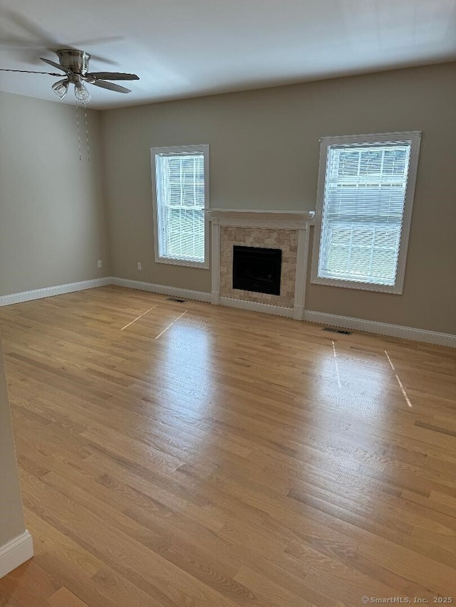 60 Pinehurst Dr Unit 60, East Haven, CT 06513 - unfurnished living room with ceiling fan, baseboards, a fireplace, and light wood-style floors