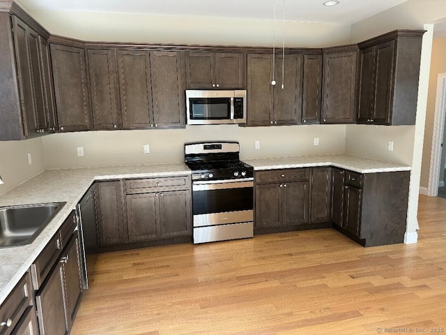 60 Pinehurst Dr Unit 60, East Haven, CT 06513 - kitchen featuring appliances with stainless steel finishes, dark brown cabinetry, a sink, light wood-style floors, and recessed lighting