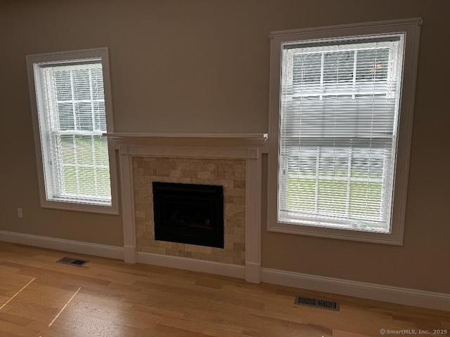 60 Pinehurst Dr Unit 60, East Haven, CT 06513 - unfurnished living room with baseboards, light wood-style flooring, plenty of natural light, and a tiled fireplace