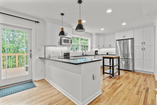 40 High Ridge Rd, Hamden, CT 06514 - kitchen featuring stainless steel appliances, a peninsula, white cabinetry, light wood-style floors, and tasteful backsplash