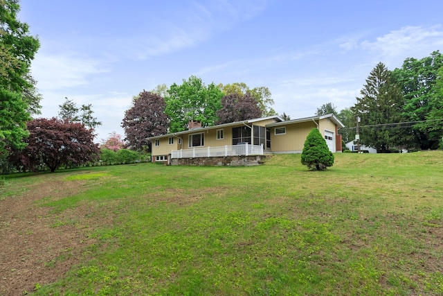 16 Ellsworth Rd, East Windsor, CT 06016 - rear view of property featuring an attached garage, a lawn, a chimney, and a sunroom