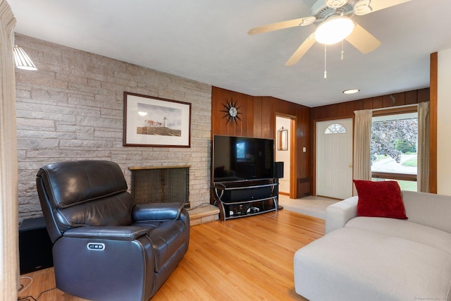 16 Ellsworth Rd, East Windsor, CT 06016 - living area with a fireplace, light wood-style floors, ceiling fan, and wooden walls