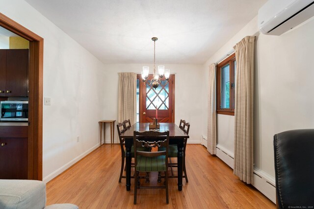 16 Ellsworth Rd, East Windsor, CT 06016 - dining space featuring a wall unit AC, a chandelier, light wood-style floors, and baseboards
