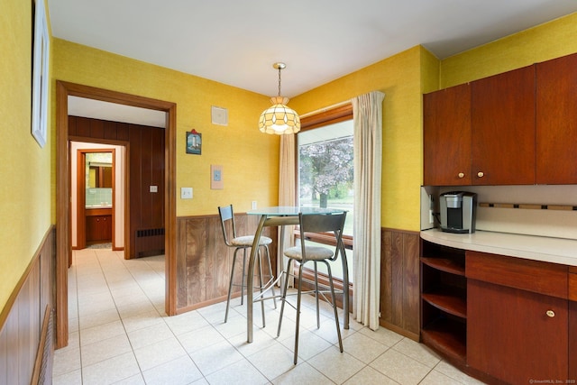 16 Ellsworth Rd, East Windsor, CT 06016 - dining area featuring a wainscoted wall, radiator heating unit, light tile patterned floors, and wood walls