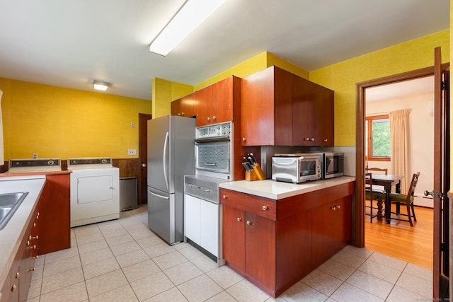 16 Ellsworth Rd, East Windsor, CT 06016 - kitchen featuring stainless steel appliances, light tile patterned floors, light countertops, and washing machine and clothes dryer
