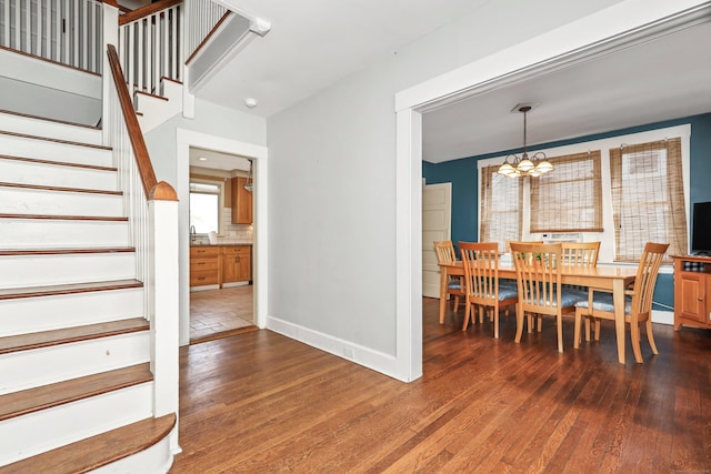 30 Birchwood St, Waterbury, CT 06708 - dining space featuring stairway, a chandelier, wood-type flooring, and baseboards