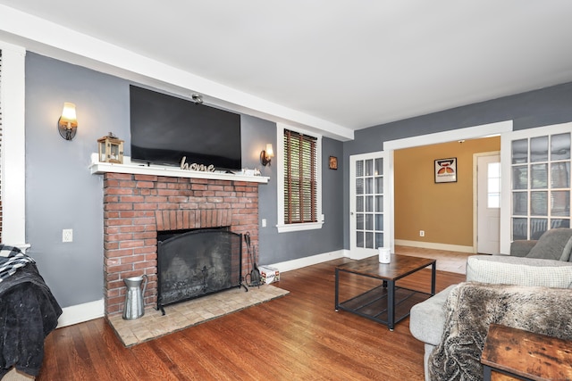 30 Birchwood St, Waterbury, CT 06708 - living room with wood finished floors, a brick fireplace, and baseboards