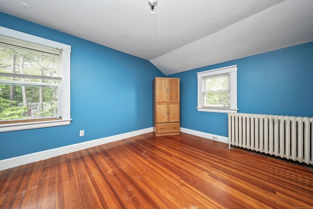 30 Birchwood St, Waterbury, CT 06708 - unfurnished room with radiator, vaulted ceiling, baseboards, and hardwood / wood-style flooring