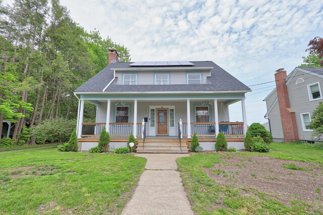 30 Birchwood St, Waterbury, CT 06708 - view of front facade with covered porch, a front yard, solar panels, and a chimney