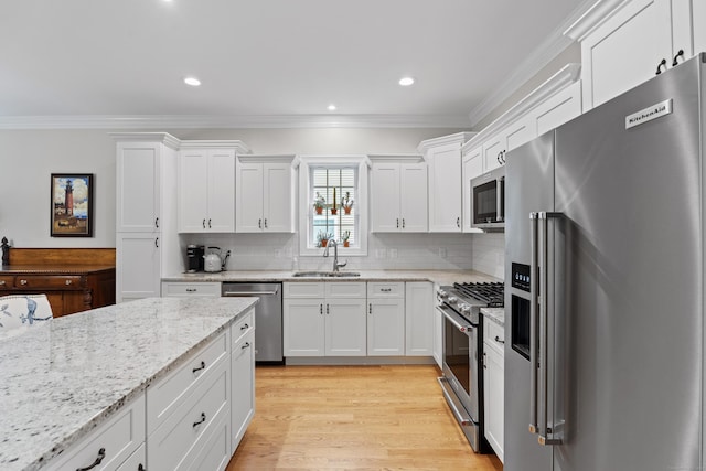 20 Webster Ln Unit 20, Middletown, CT 06457 - kitchen featuring high end appliances, a sink, ornamental molding, white cabinets, and tasteful backsplash
