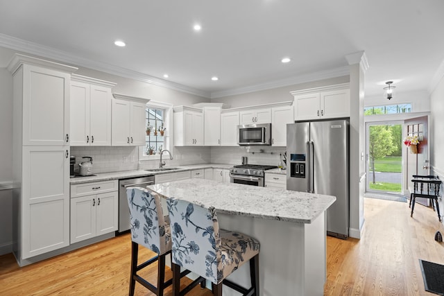 20 Webster Ln Unit 20, Middletown, CT 06457 - kitchen featuring appliances with stainless steel finishes, a sink, light wood-style flooring, white cabinetry, and ornamental molding