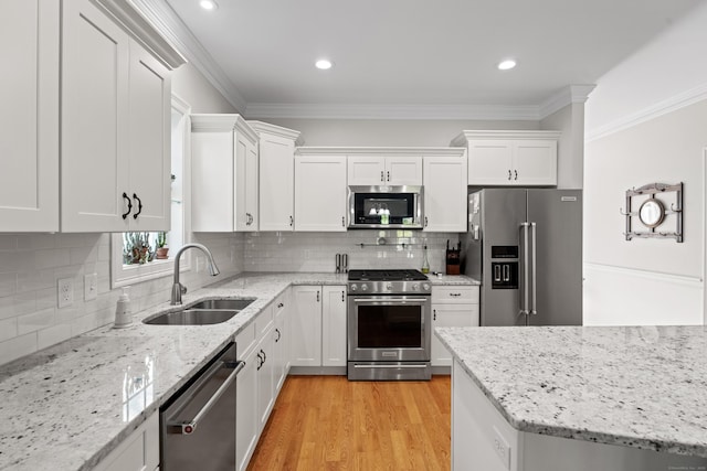 20 Webster Ln Unit 20, Middletown, CT 06457 - kitchen with appliances with stainless steel finishes, a sink, white cabinets, crown molding, and light wood-style floors