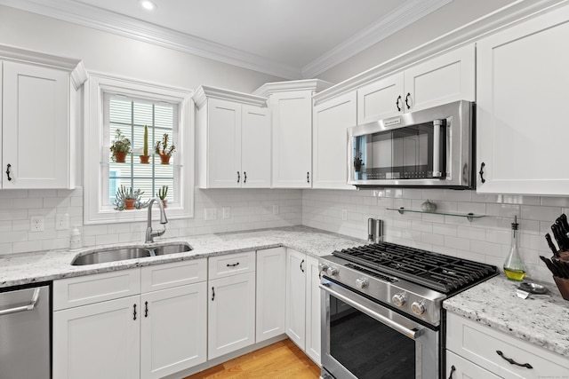 20 Webster Ln Unit 20, Middletown, CT 06457 - kitchen featuring appliances with stainless steel finishes, a sink, ornamental molding, and white cabinetry