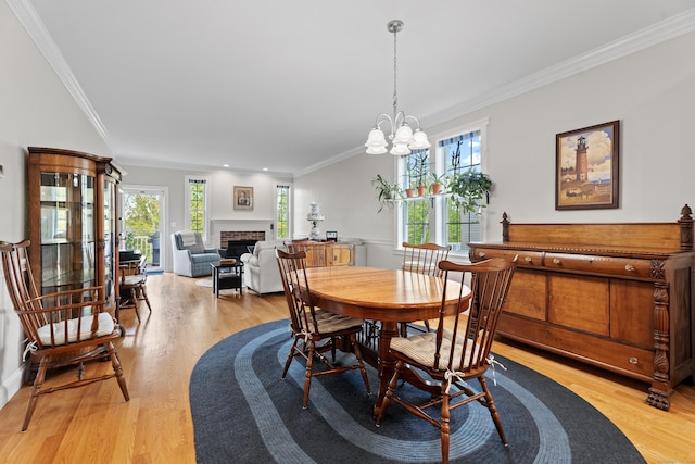 20 Webster Ln Unit 20, Middletown, CT 06457 - dining area featuring crown molding, light wood-style flooring, a brick fireplace, and a chandelier