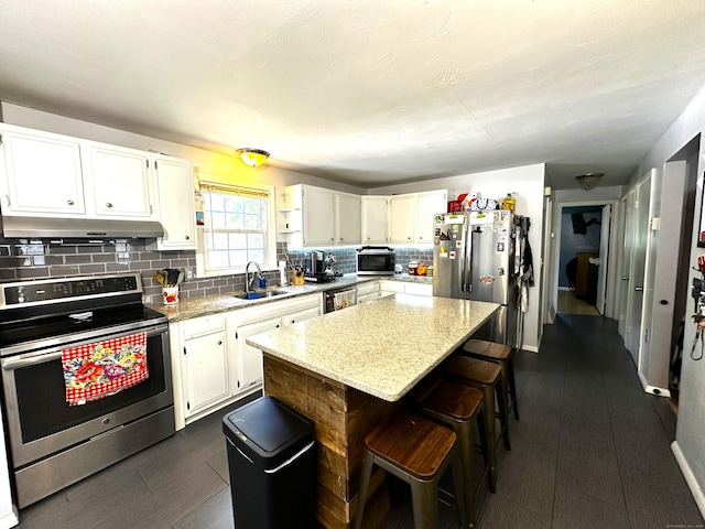 17 Aspen Ct, Norwich, CT 06360 - kitchen featuring appliances with stainless steel finishes, under cabinet range hood, tasteful backsplash, white cabinets, and light stone counters