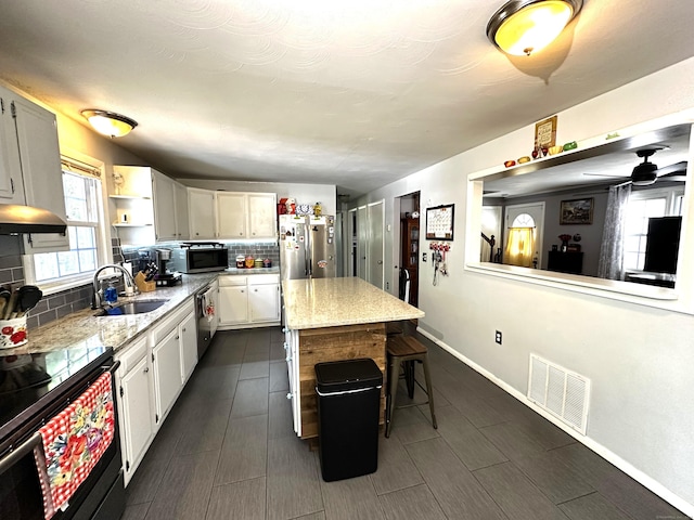 17 Aspen Ct, Norwich, CT 06360 - kitchen with a sink, appliances with stainless steel finishes, backsplash, a center island, and white cabinetry