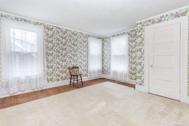 650 Broadview Ter, Hartford, CT 06106 - empty room featuring wallpapered walls, ornamental molding, baseboards, and wood finished floors