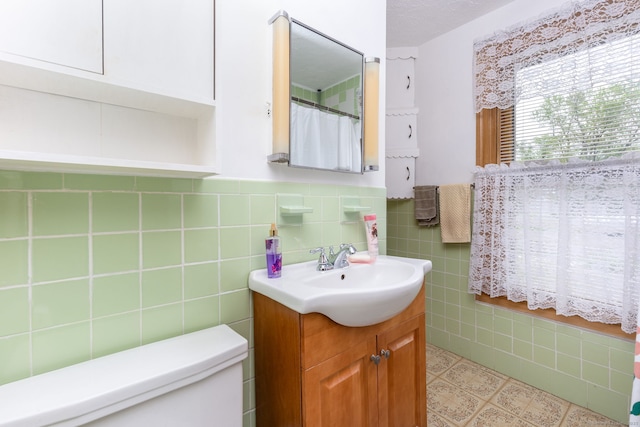 650 Broadview Ter, Hartford, CT 06106 - bathroom with toilet, vanity, tile walls, and a wainscoted wall