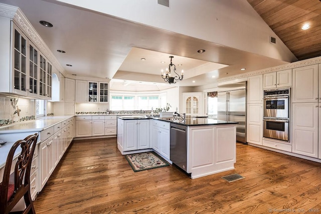 14 Great Marsh Rd, Westport, CT 06880 - kitchen with appliances with stainless steel finishes, a chandelier, dark wood finished floors, glass insert cabinets, and white cabinetry