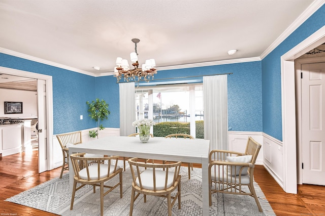 14 Great Marsh Rd, Westport, CT 06880 - dining area featuring wood finished floors, a chandelier, a wainscoted wall, and crown molding