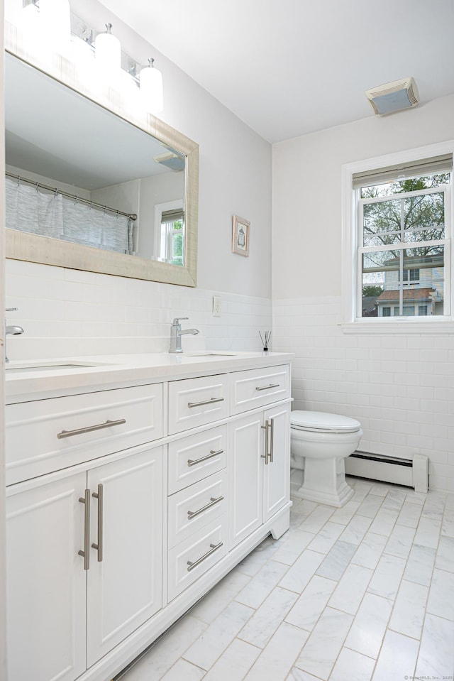 23 Hale St, Westport, CT 06880 - bathroom with baseboard heating, double vanity, tile walls, toilet, and wainscoting