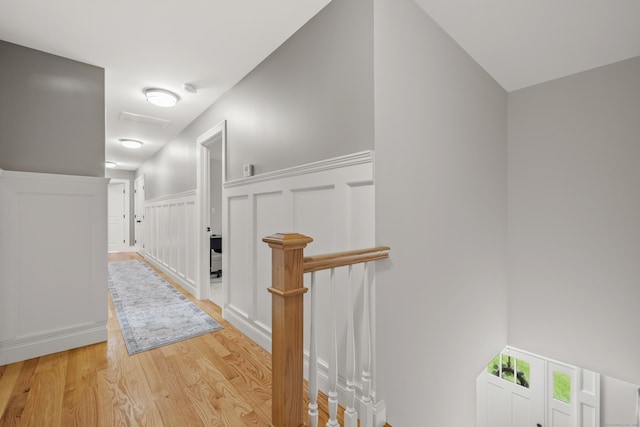 261 W St, Hebron, CT 06248 - corridor featuring a decorative wall, light wood-type flooring, and a wainscoted wall