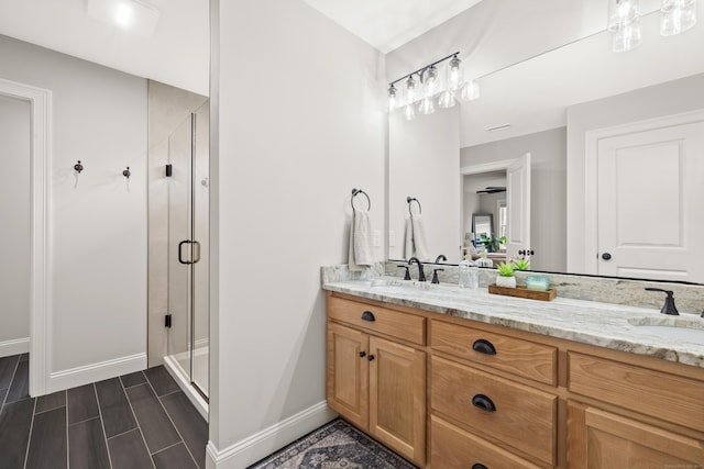 261 W St, Hebron, CT 06248 - bathroom featuring double vanity, a stall shower, baseboards, and wood finish floors