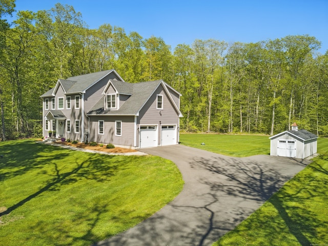 261 W St, Hebron, CT 06248 - view of front facade featuring asphalt driveway, a front yard, an outdoor structure, and a view of trees