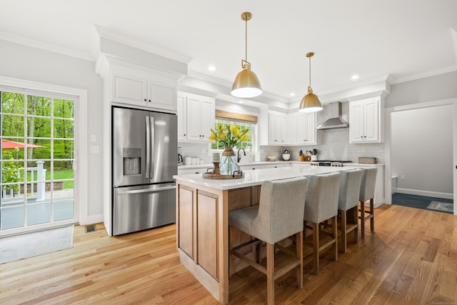 261 W St, Hebron, CT 06248 - kitchen with stainless steel refrigerator with ice dispenser, wall chimney exhaust hood, a center island, tasteful backsplash, and ornamental molding