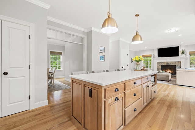261 W St, Hebron, CT 06248 - kitchen with a fireplace, light wood finished floors, light countertops, hanging light fixtures, and baseboards