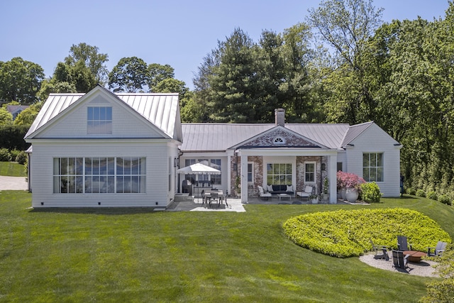 7 Hanna Ln, Essex, CT 06426 - rear view of house featuring a yard, a patio, a chimney, a standing seam roof, and an outdoor living space