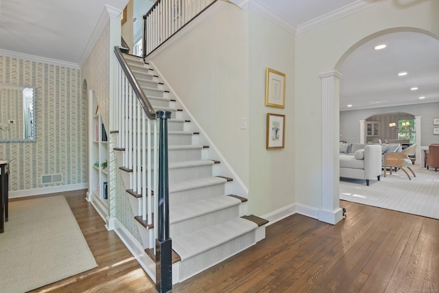 49 Dogwood Ln, New Canaan, CT 06840 - stairway featuring arched walkways, hardwood / wood-style floors, baseboards, crown molding, and wallpapered walls