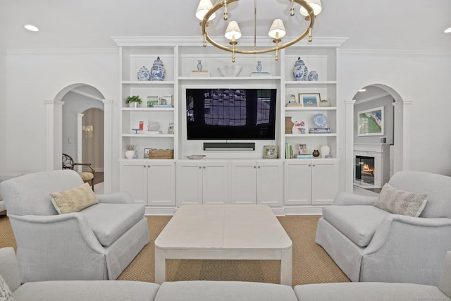 49 Dogwood Ln, New Canaan, CT 06840 - living area featuring crown molding, arched walkways, a chandelier, built in features, and a high end fireplace
