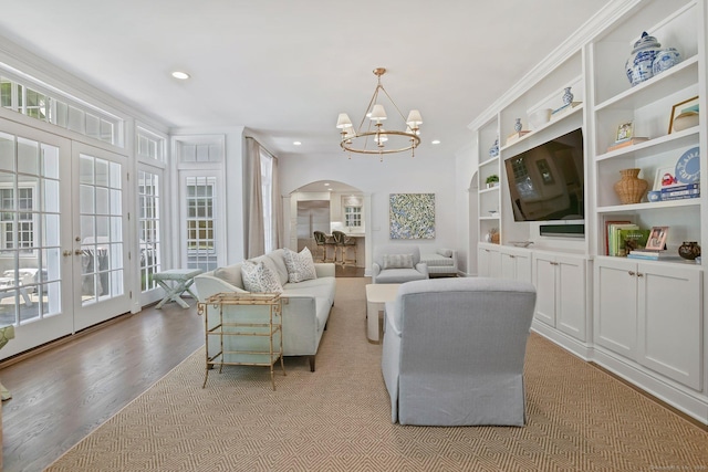 49 Dogwood Ln, New Canaan, CT 06840 - living area featuring arched walkways, french doors, a chandelier, light wood-style flooring, and recessed lighting
