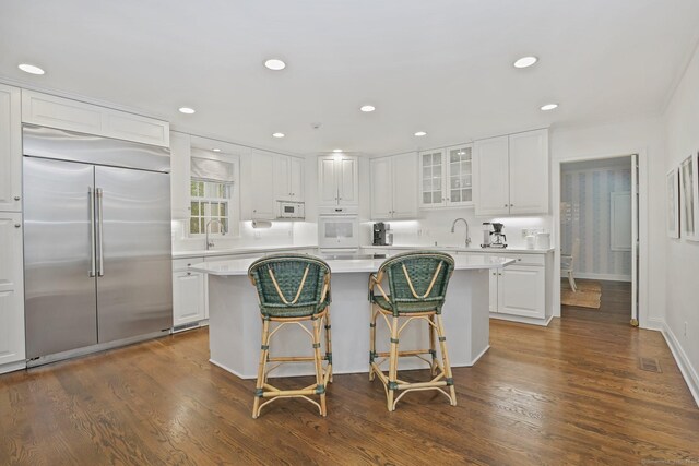 49 Dogwood Ln, New Canaan, CT 06840 - kitchen with white appliances, glass insert cabinets, a kitchen island, white cabinetry, and light countertops
