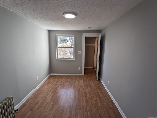 386 Platt Ave, West Haven, CT 06516 - unfurnished room with radiator heating unit, wood finished floors, a textured ceiling, and baseboards