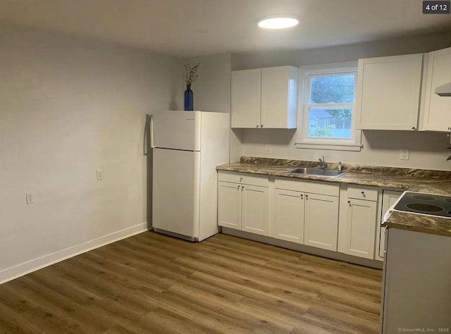 386 Platt Ave, West Haven, CT 06516 - kitchen with freestanding refrigerator, a sink, white cabinets, dark wood finished floors, and dark countertops