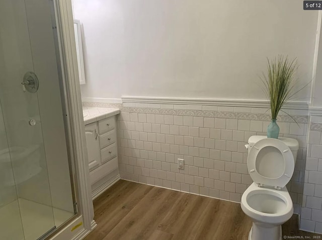386 Platt Ave, West Haven, CT 06516 - full bathroom featuring tile walls, a shower stall, toilet, wood finished floors, and wainscoting