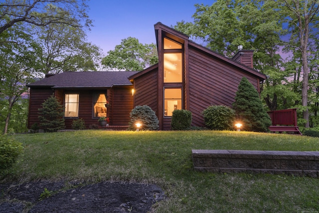 view of front of home featuring a chimney and a front lawn