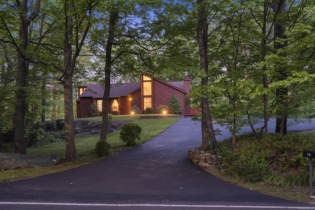 view of front of property with asphalt driveway and a chimney
