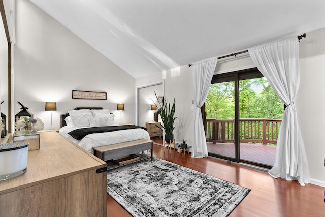 bedroom with access to outside, vaulted ceiling, and wood finished floors