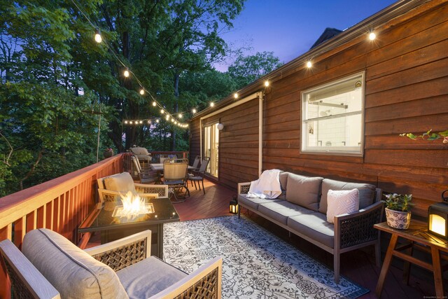 deck featuring an outdoor living space with a fire pit