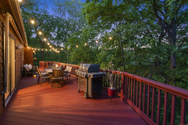 deck with outdoor dining space and area for grilling
