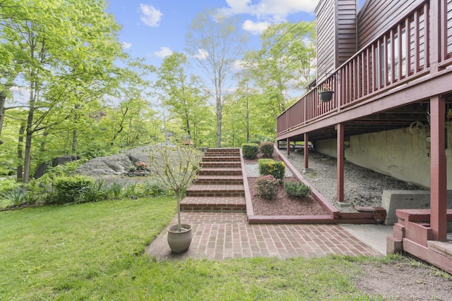 view of green lawn with a patio, stairway, and a wooden deck
