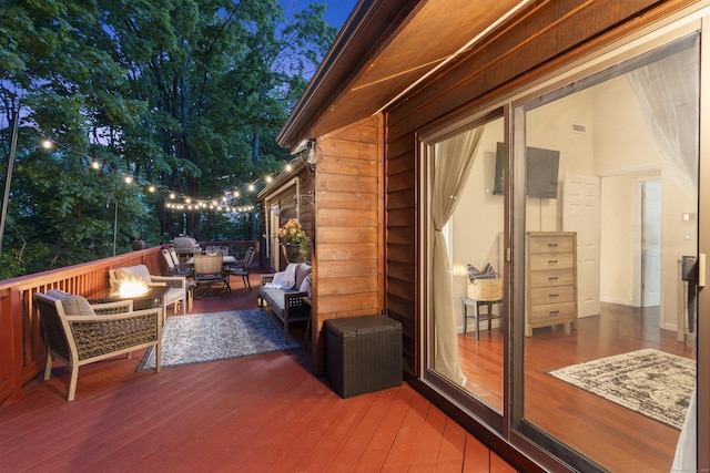 wooden deck featuring an outdoor living space with a fire pit