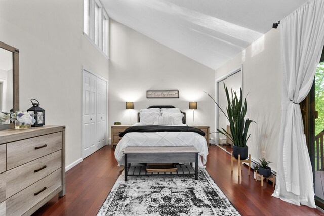 bedroom featuring dark wood-type flooring, baseboards, and high vaulted ceiling
