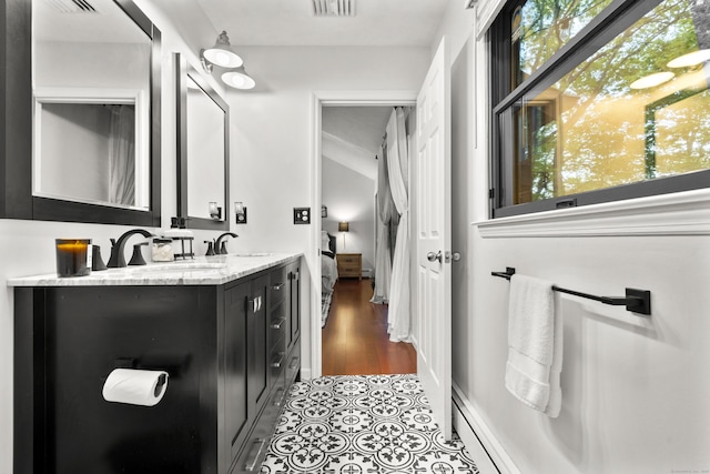 bathroom with double vanity, vaulted ceiling, and ensuite bathroom