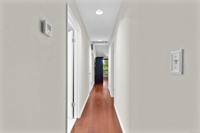 hall with baseboards, wood finished floors, and recessed lighting